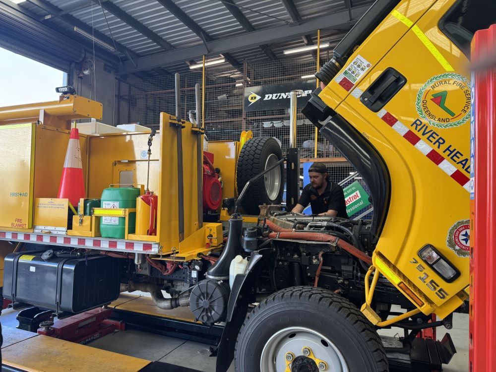 A Garage Scene with A Yellow Service Vehicle Being Repaired — Pialba Brake Clutch & Steering in Pialba, QLD
