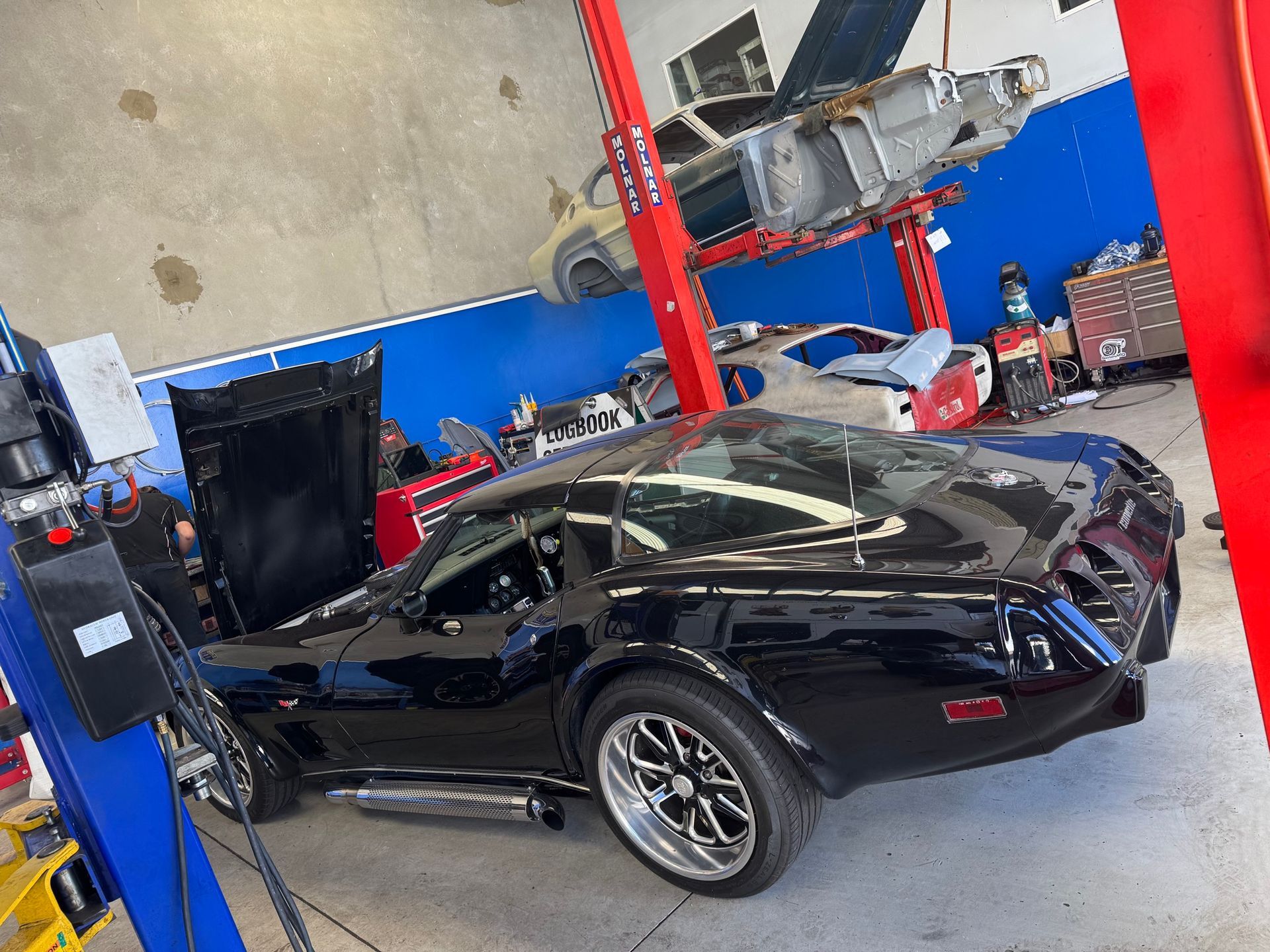 Two Cars Are Sitting on a Lift in a Garage — Pialba Brake Clutch & Steering in Pialba, QLD