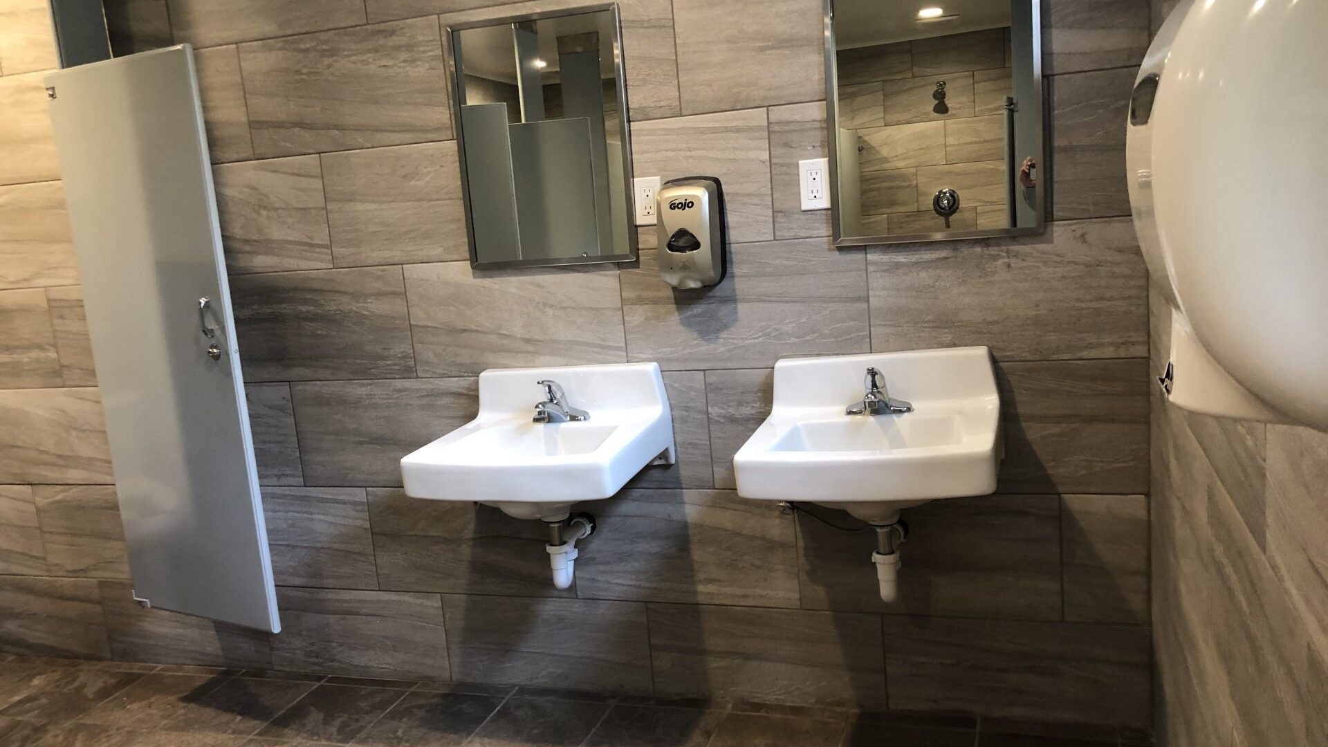 A bathroom with two sinks and two mirrors on the wall.