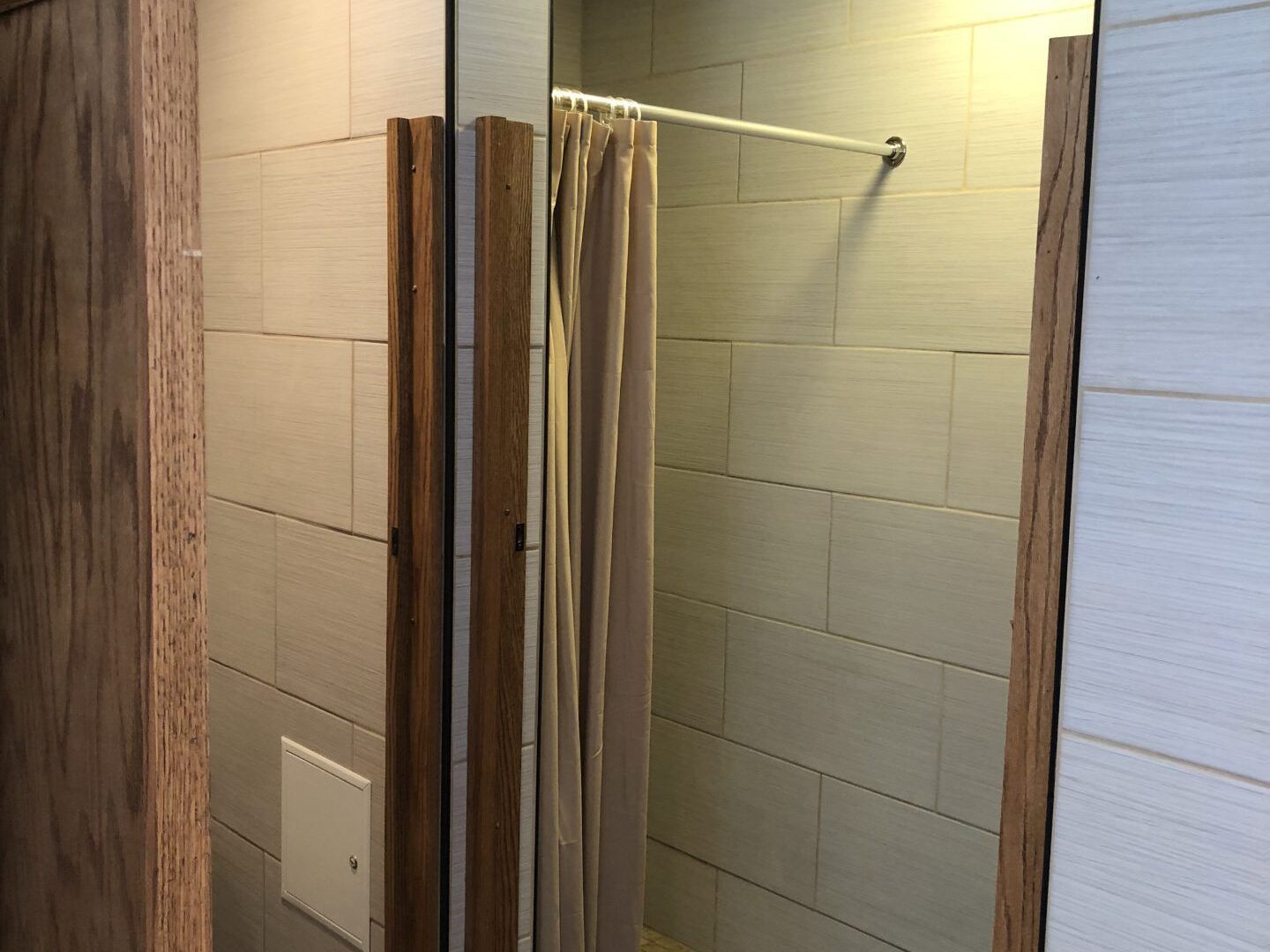 A bathroom with a shower curtain and a mirror.