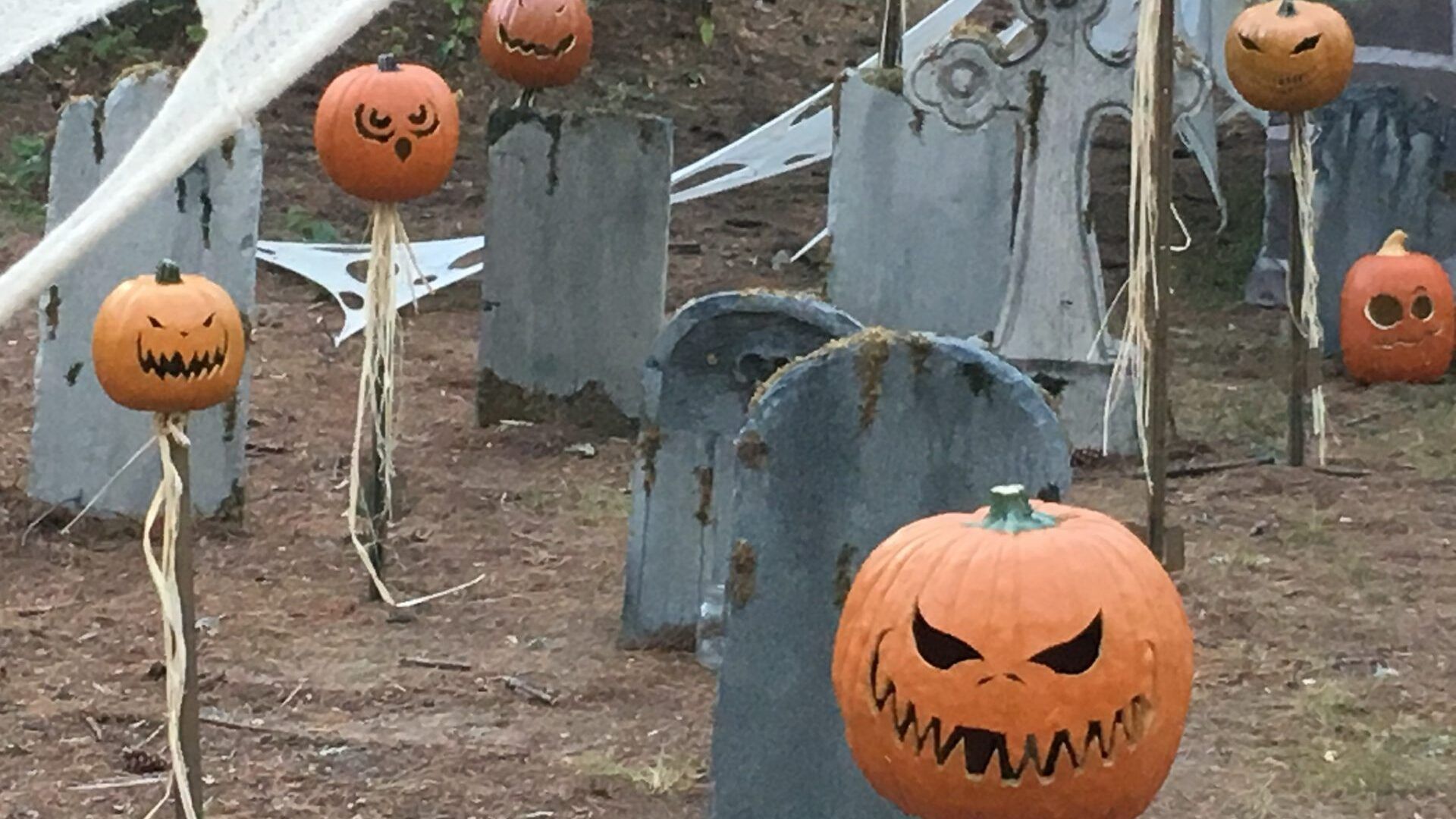 A cemetery with pumpkins and graves decorated for halloween