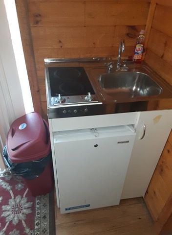 A small kitchen with a sink , stove and refrigerator.