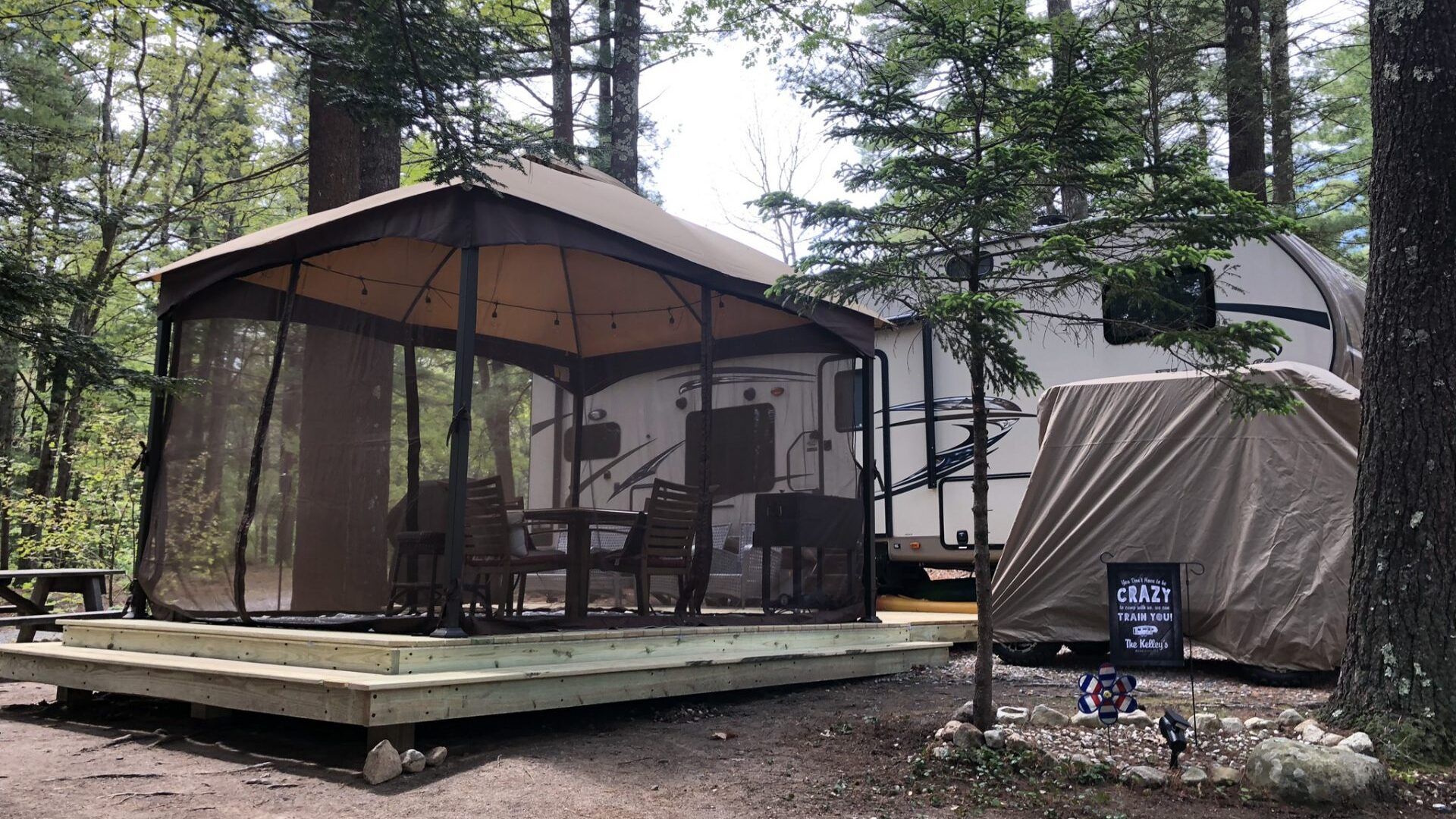 There is a gazebo with a screened in porch in the middle of the woods.