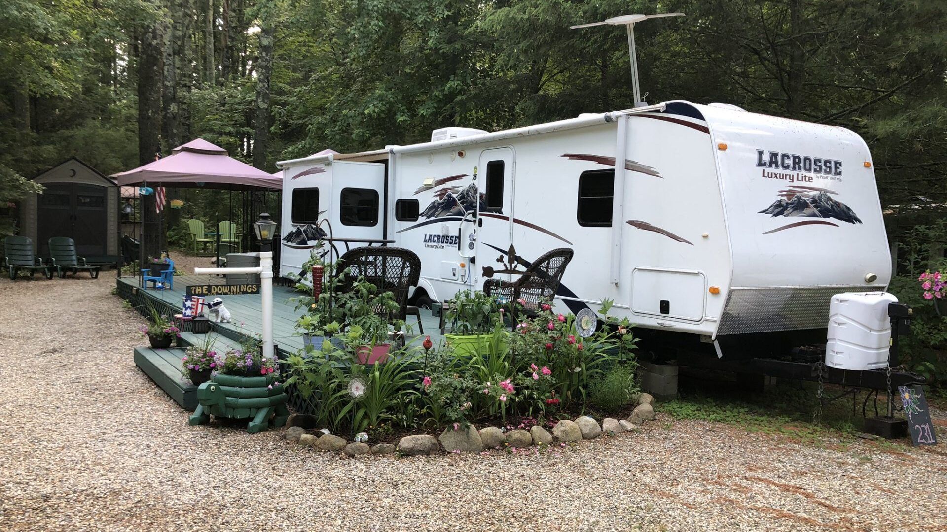 A white rv is parked in a gravel lot.