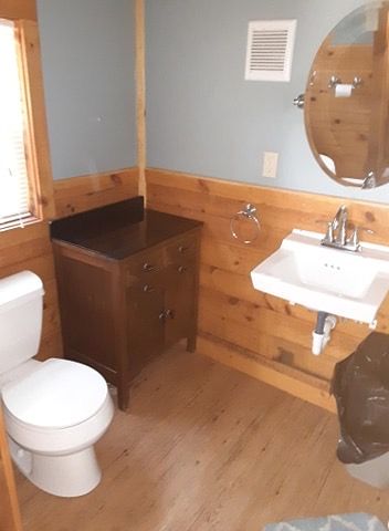 A bathroom with a toilet a sink and a mirror