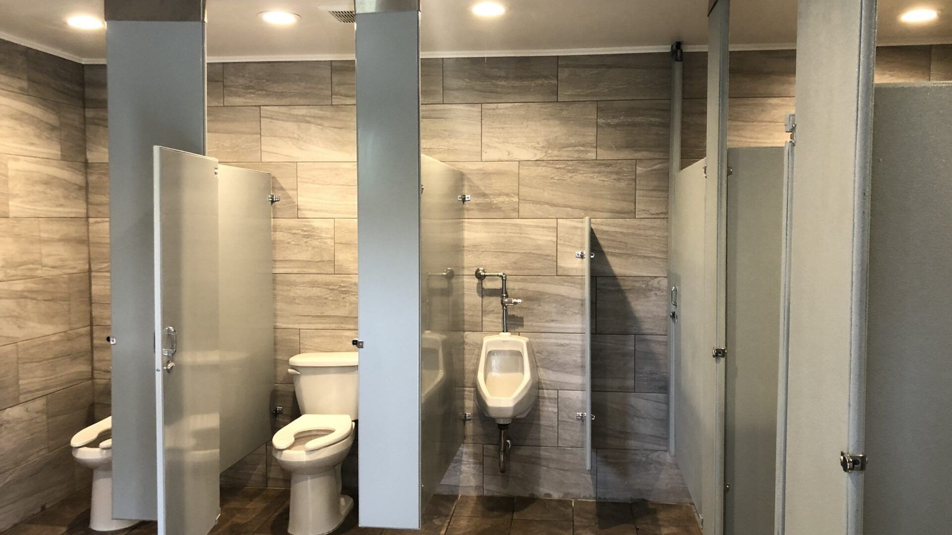 A public restroom with toilets and urinals lined up in a row.