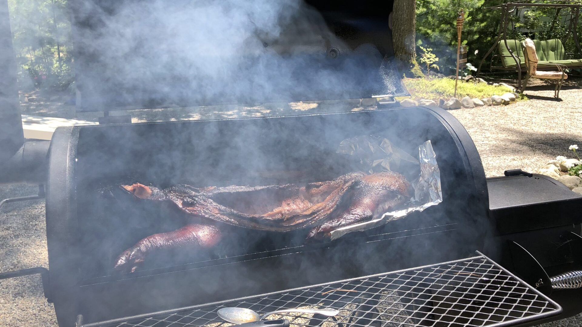 A large piece of meat is being cooked on a grill.