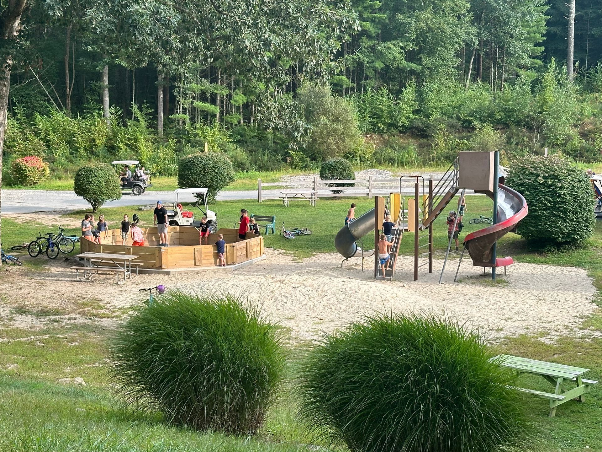 A playground with a slide and people playing in it