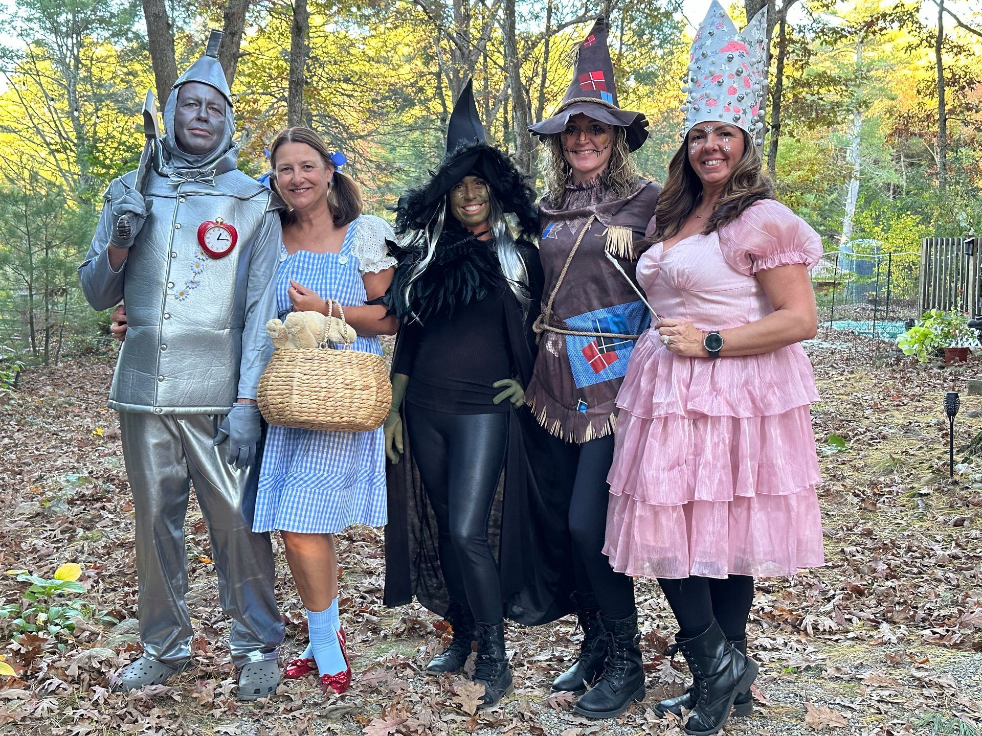 A group of people dressed in costumes from the wizard of oz are posing for a picture.