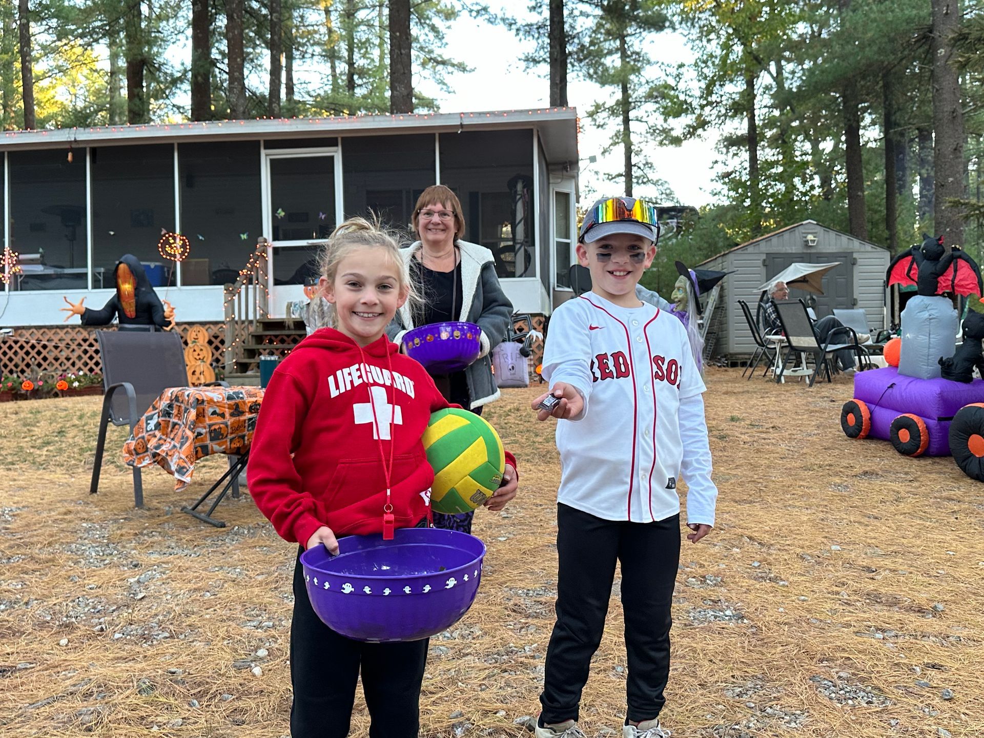 A boy and a girl are standing next to each other holding buckets of candy.