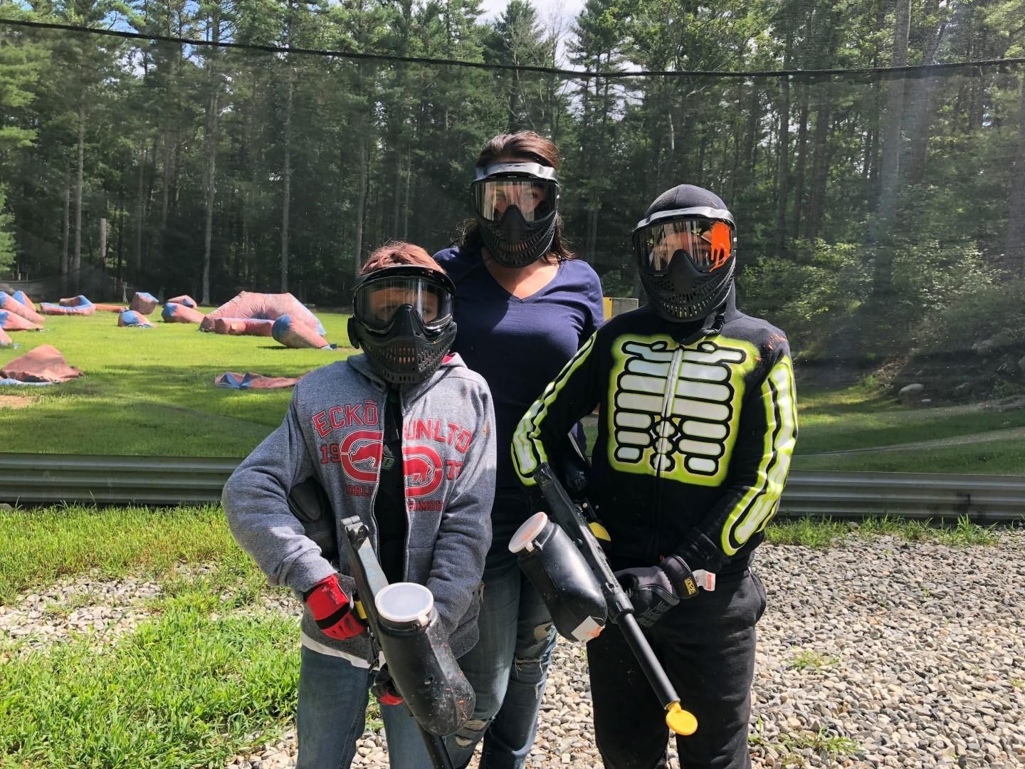 A group of people wearing paintball masks are standing next to each other.