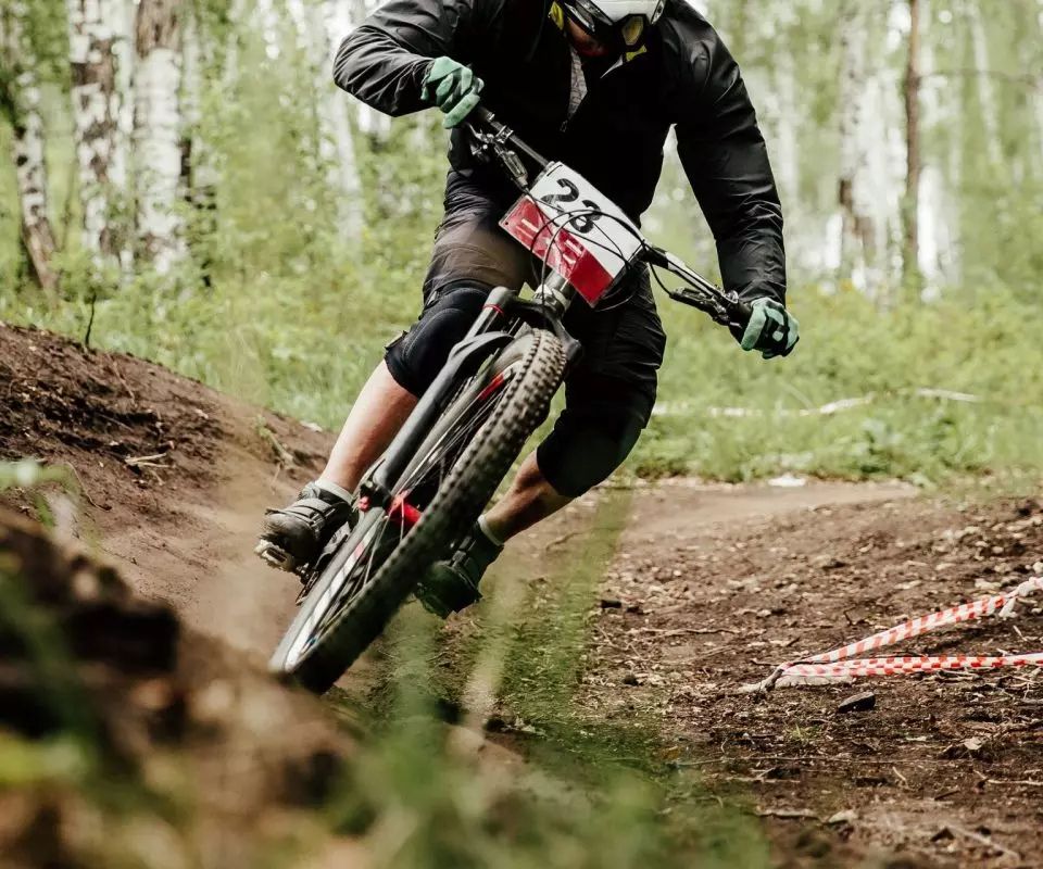 A man is riding a mountain bike down a dirt trail.