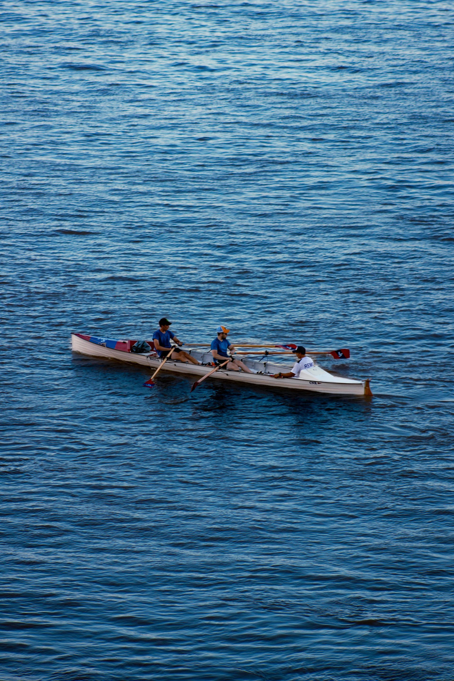 Two people are rowing a boat in the ocean.