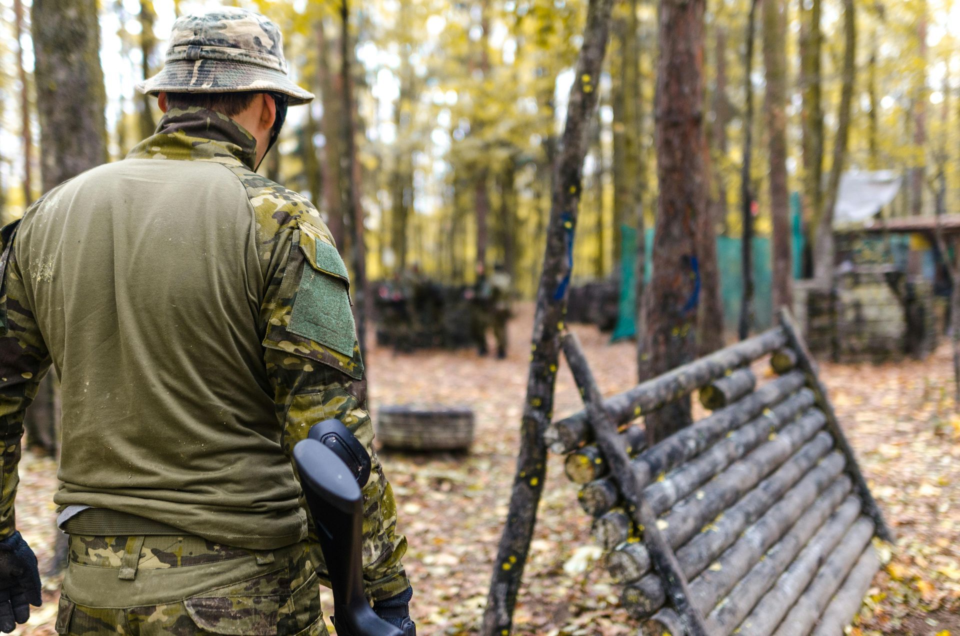 A man is playing paintball on an inflatable field.