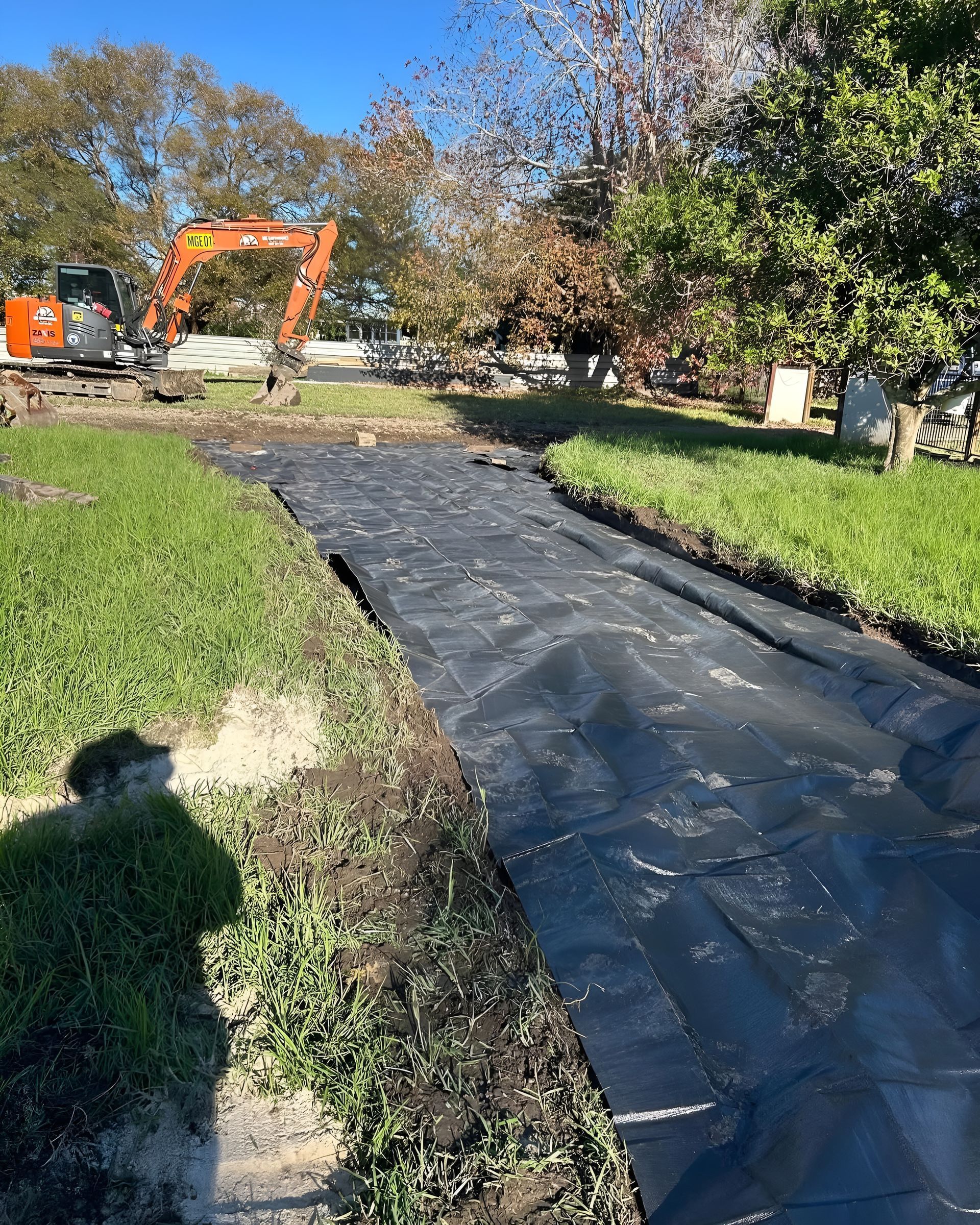 Black Landscape Fabric Laid in a Ditch in a Grassy Yard — MG Earthworks and Plant Hire in Kempsey, NSW
