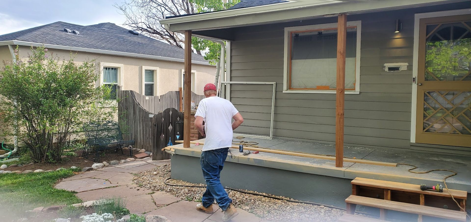 A man is standing on the porch of a house.
