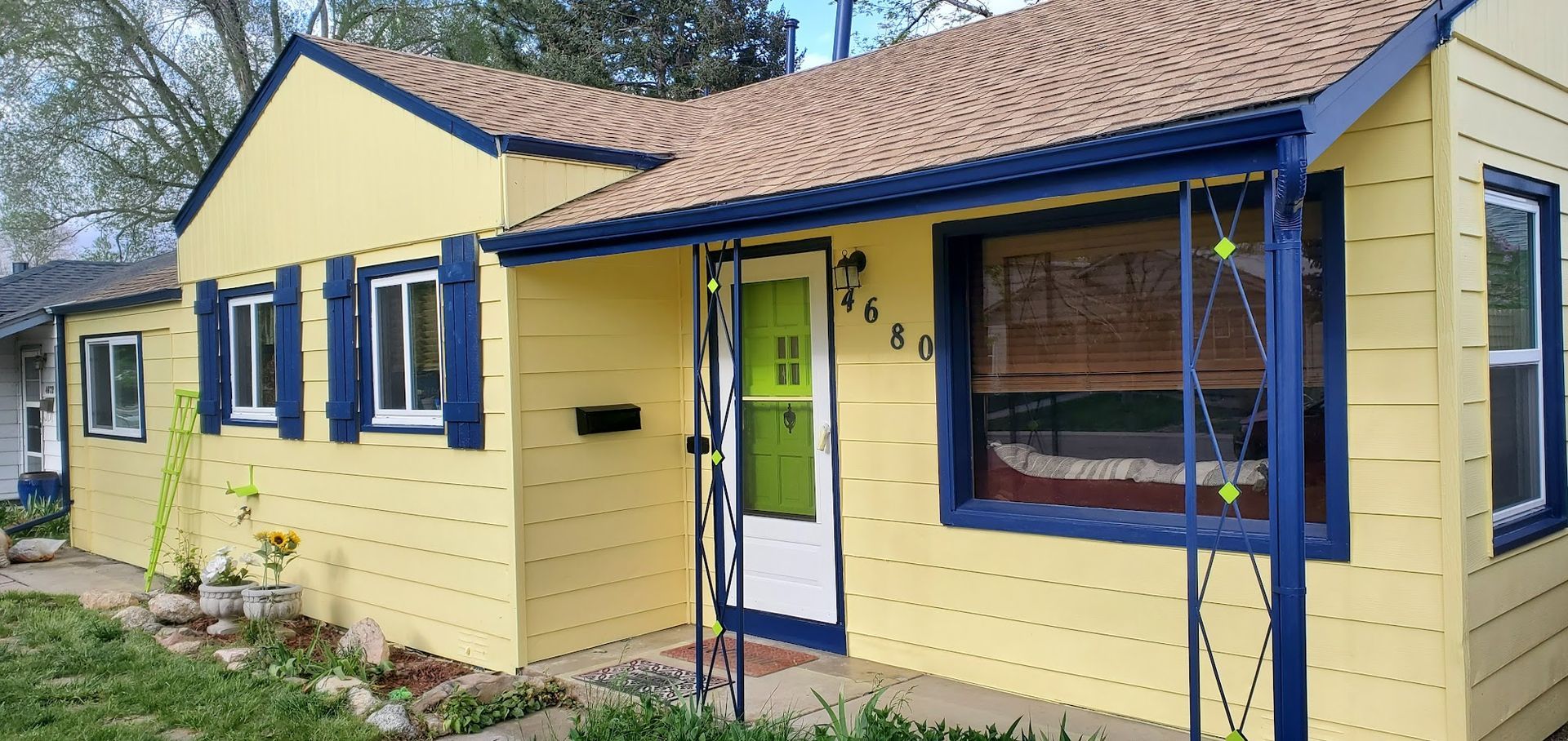 A yellow house with blue trim and shutters