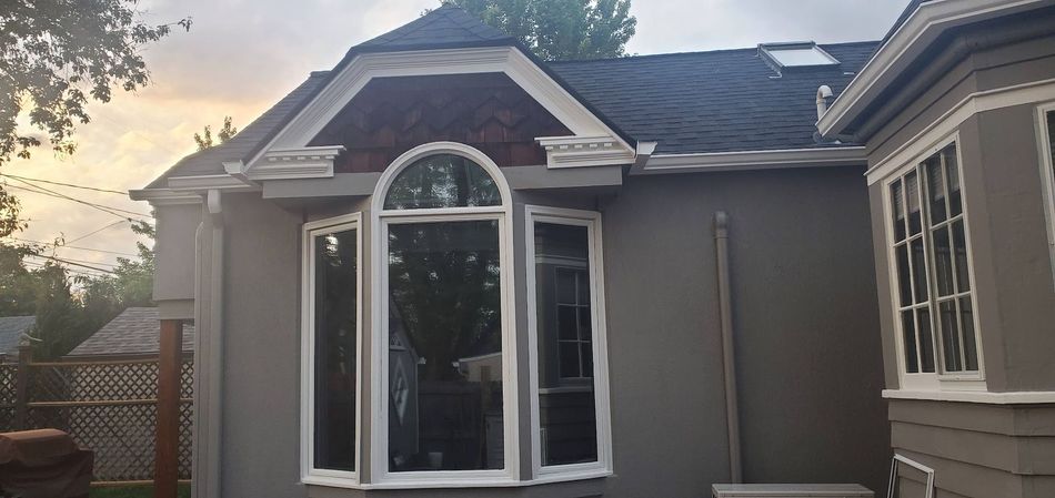 A house with a large window on the side of it.