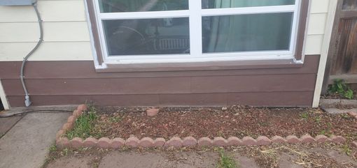 A house with a window and a garden in front of it.