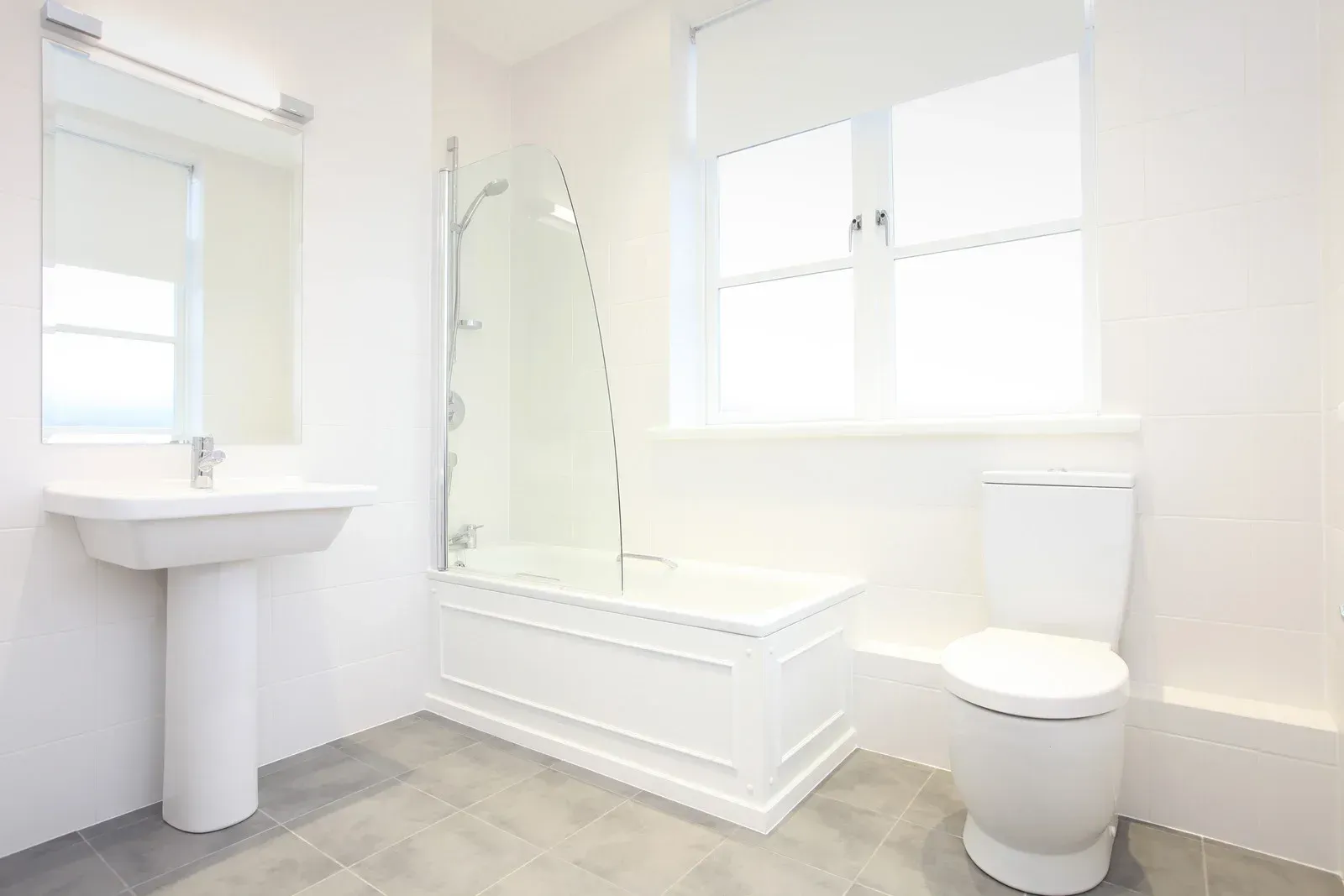 A bathroom with a toilet , sink and bathtub.
