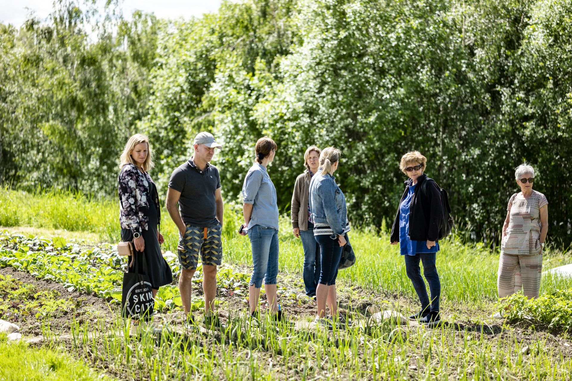 a group of people are standing in a grassy field .