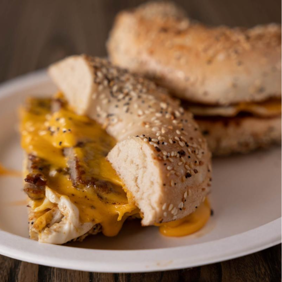 Toasted everything bagel sandwich filled with egg, sausage, and melted cheese.