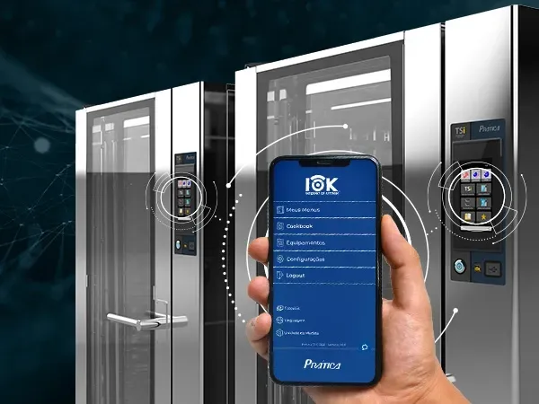 Una persona sostiene un teléfono celular frente a un refrigerador.