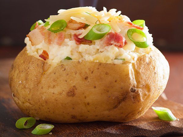 Una papa al horno rellena de arroz, queso, tocino y cebollas verdes.