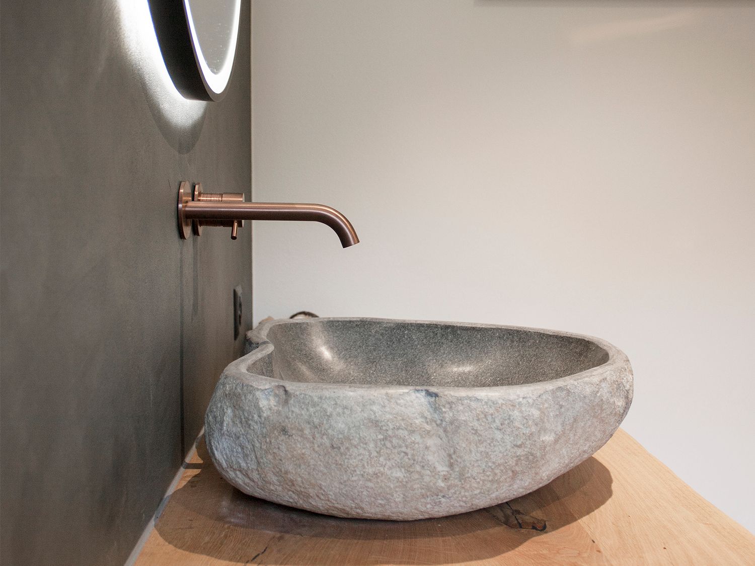 Ein Badezimmer mit einem Steinwaschbecken und einem Spiegel