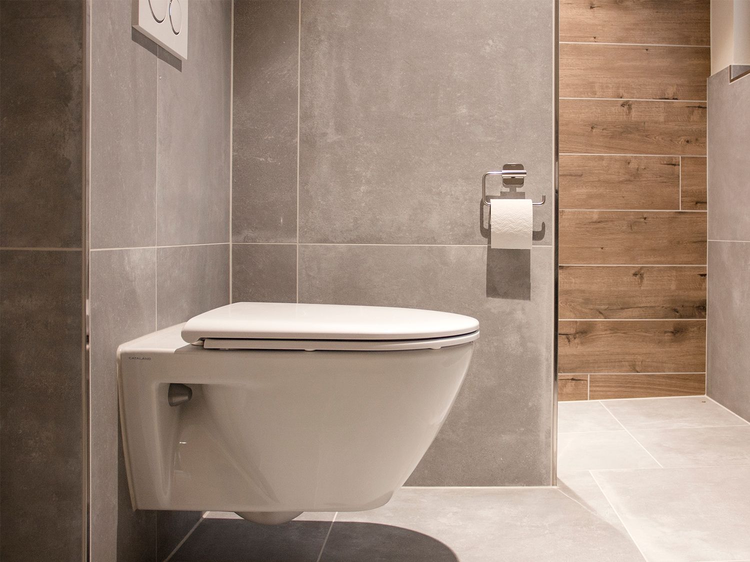 Eine Toilette ist in einem Badezimmer an der Wand montiert