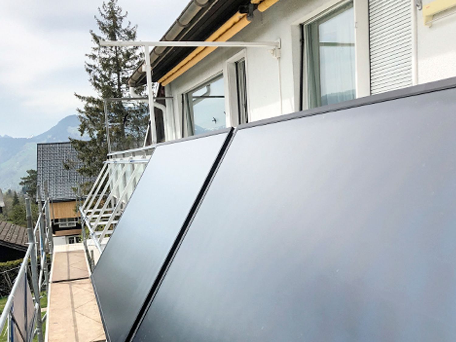 Ein Balkon mit zwei schwarzen Solarmodulen darauf