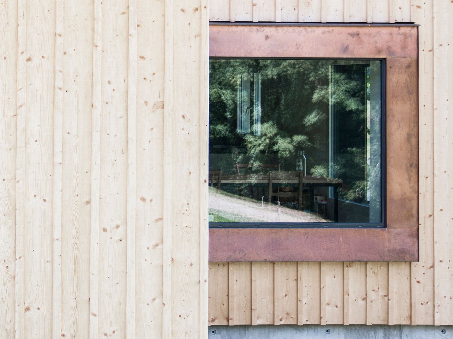 Ein Fenster an einem Holzgebäude mit einem Kupferrahmen