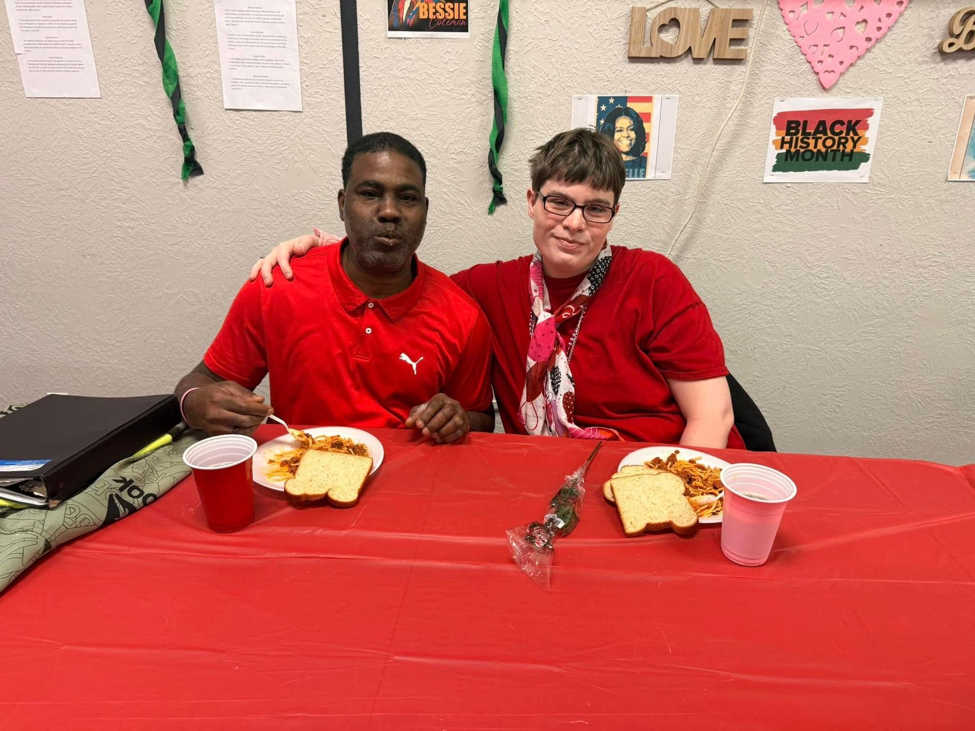 A man and a woman are sitting at a table with plates of food.
