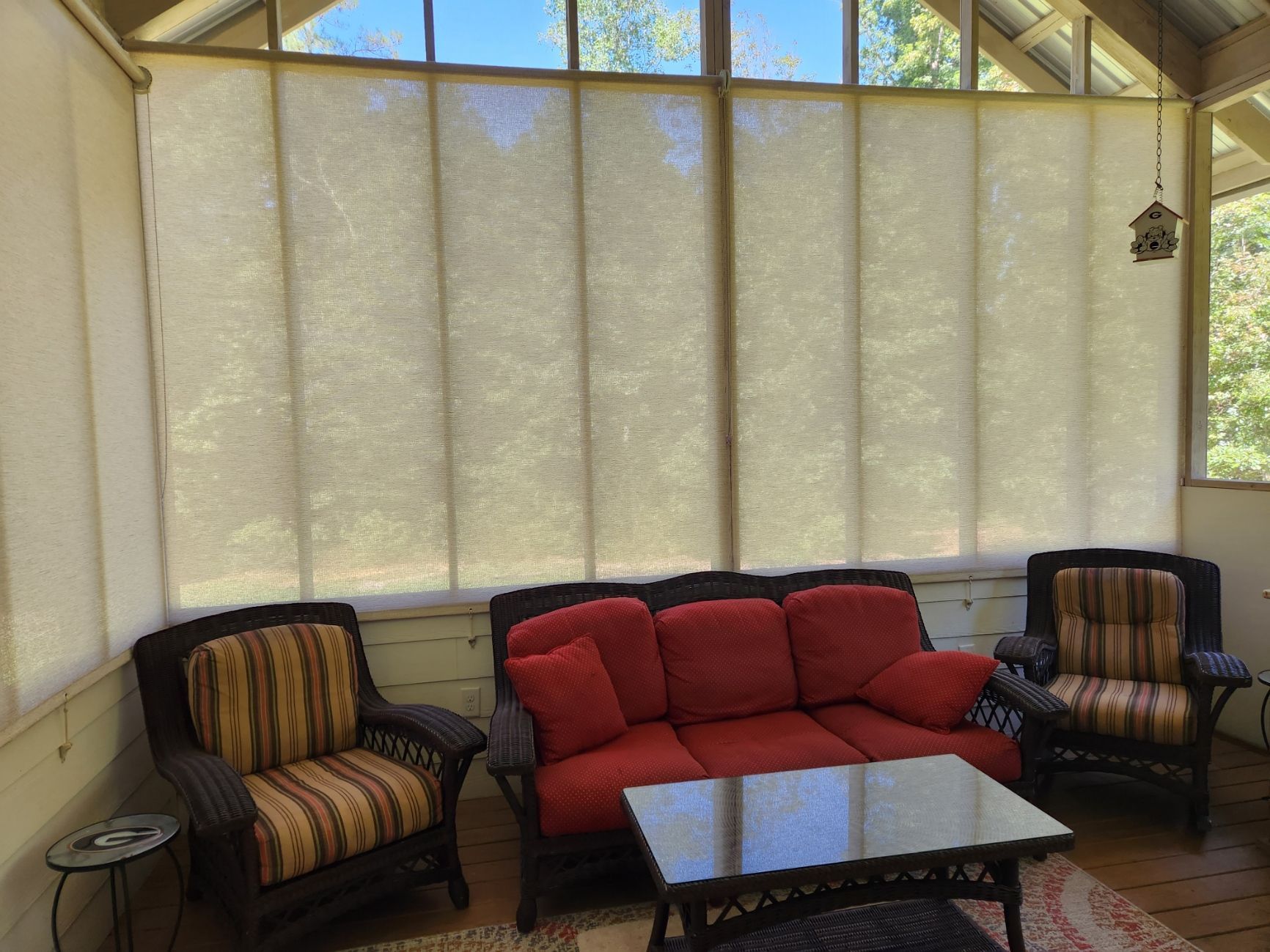 A living room with a red couch and two chairs