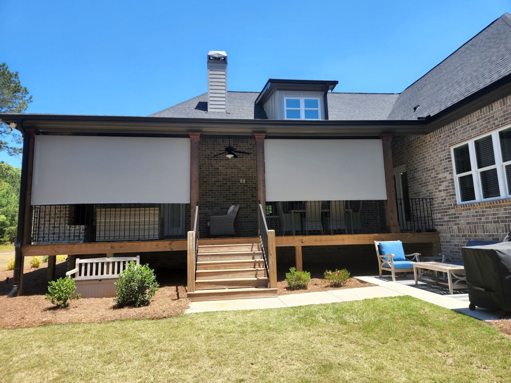 A large house with a screened in porch and patio.