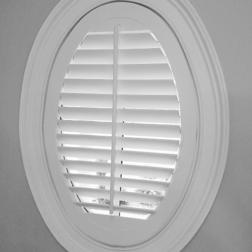 A round window with white shutters on it