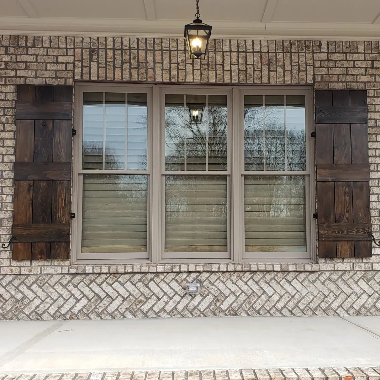 A window with wooden shutters on a brick wall