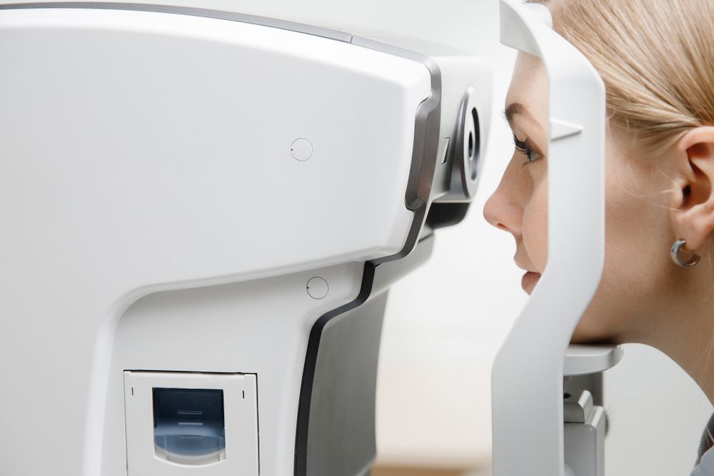 Woman Undergoing an Eye Exam With a White Medical Scanning Device — Peninsula Eyecare Izzards Optometrists in Woy Woy, NSW