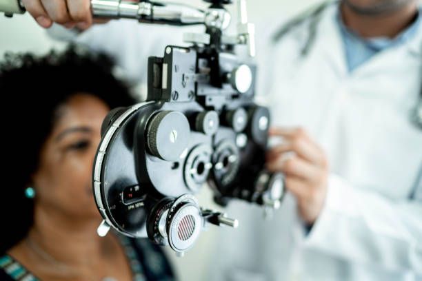 An Eye Doctor Conducts a Vision Exam Using a Phoropter on a Patient — Peninsula Eyecare Izzards Optometrists in Woy Woy, NSW