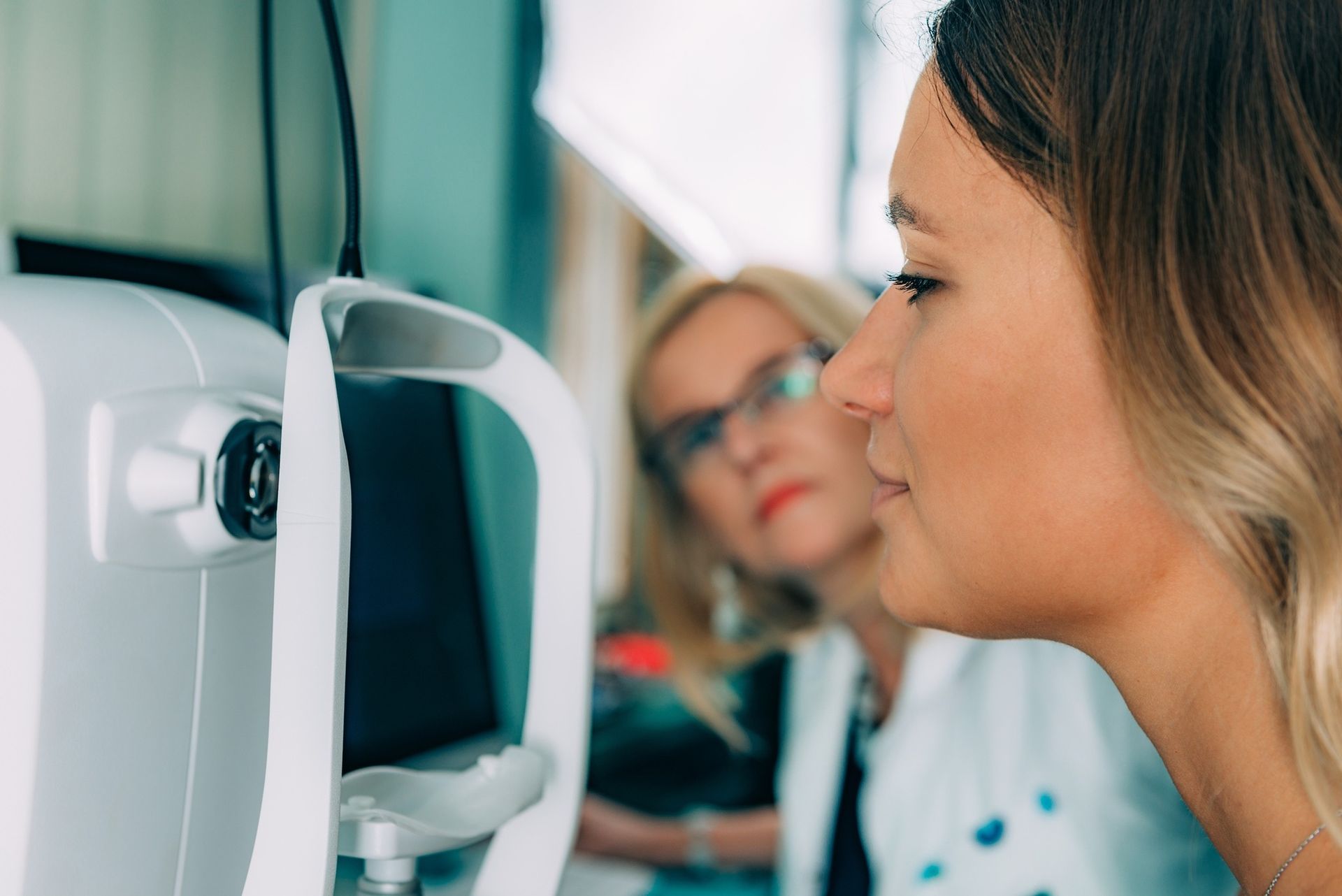 A Person Has Their Chin Rested on a White Medical Device — Peninsula Eyecare Izzards Optometrists in Point Clare, NSW