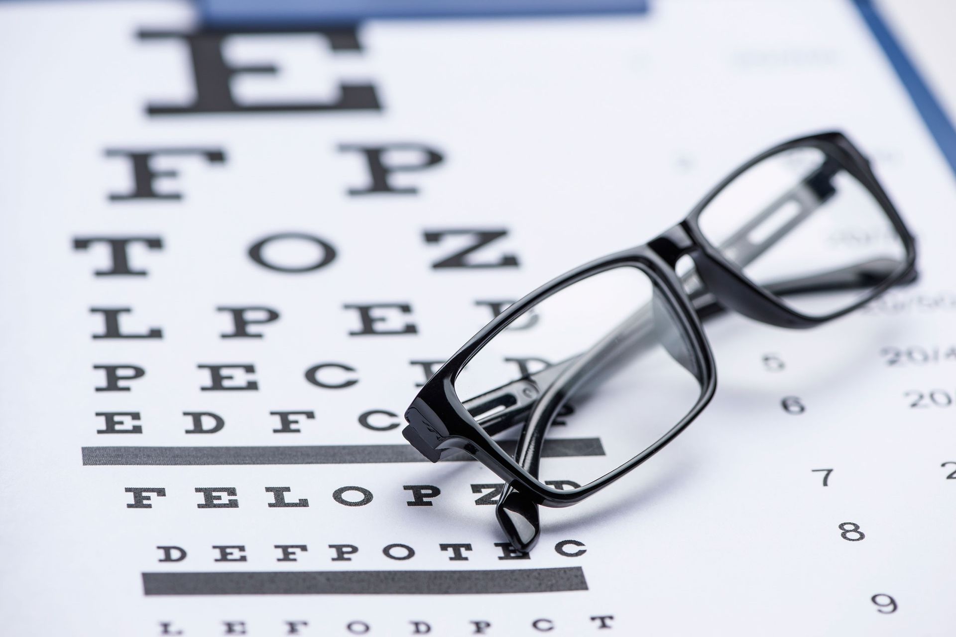 Eyeglasses on an Eye Chart — Peninsula Eyecare Izzards Optometrists in Woy Woy, NSW