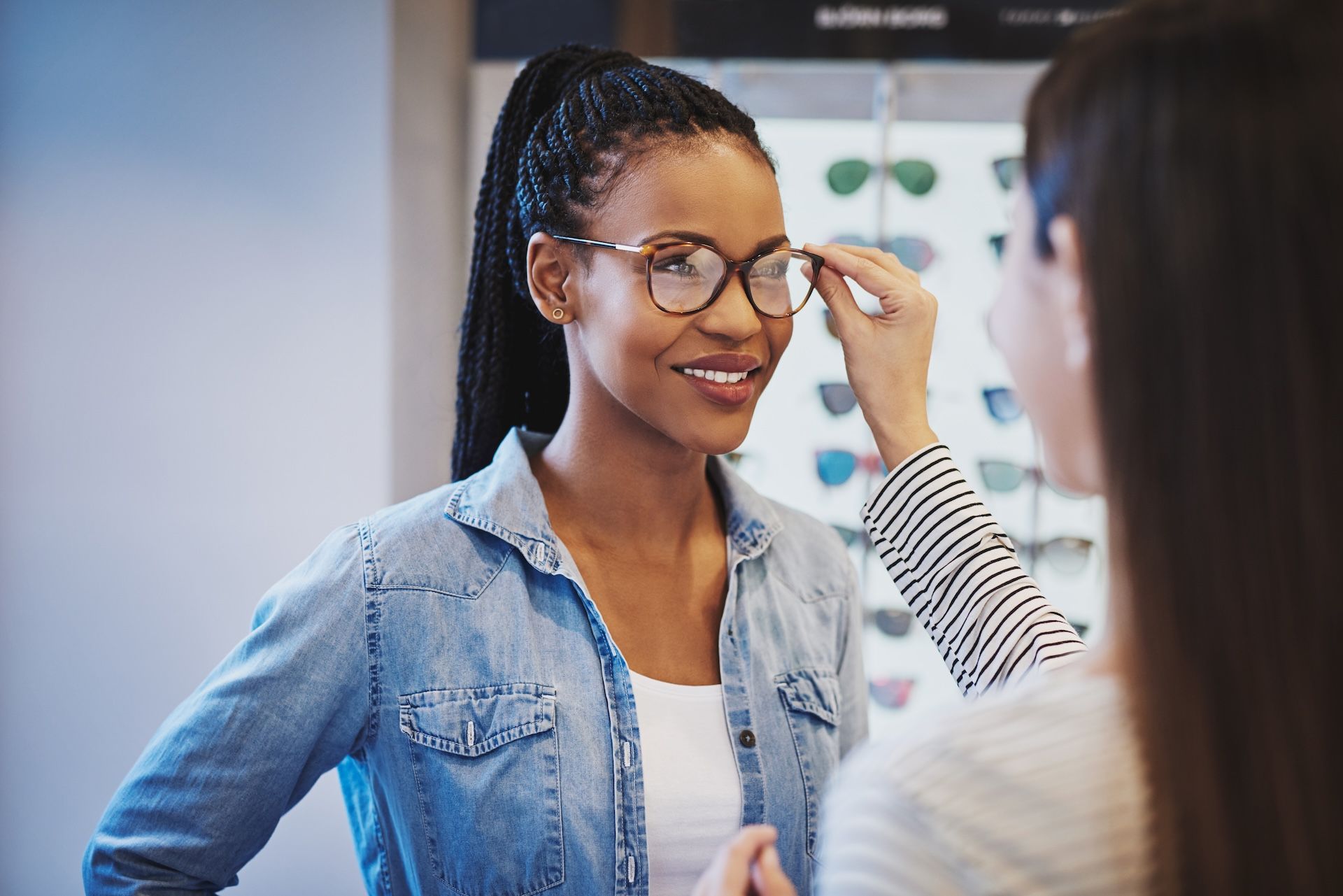 Woman Smiling as Someone Adjusts Her Glasses — Peninsula Eyecare Izzards Optometrists in Woy Woy, NSW