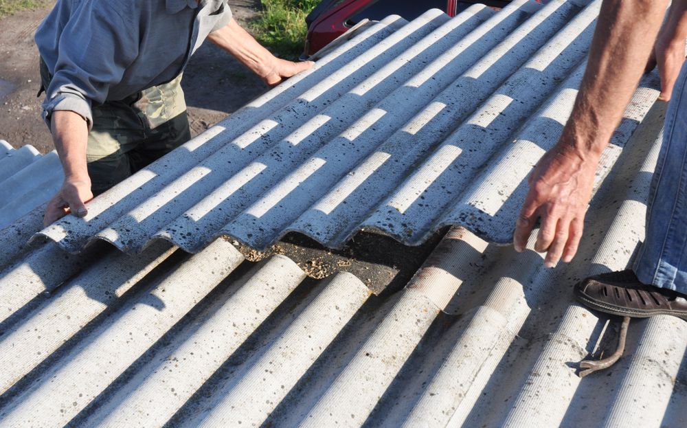 Two People Installing Gray Corrugated Roofing Panels — Wilko Plate (Aust) Pty Ltd in Cairns, QLD