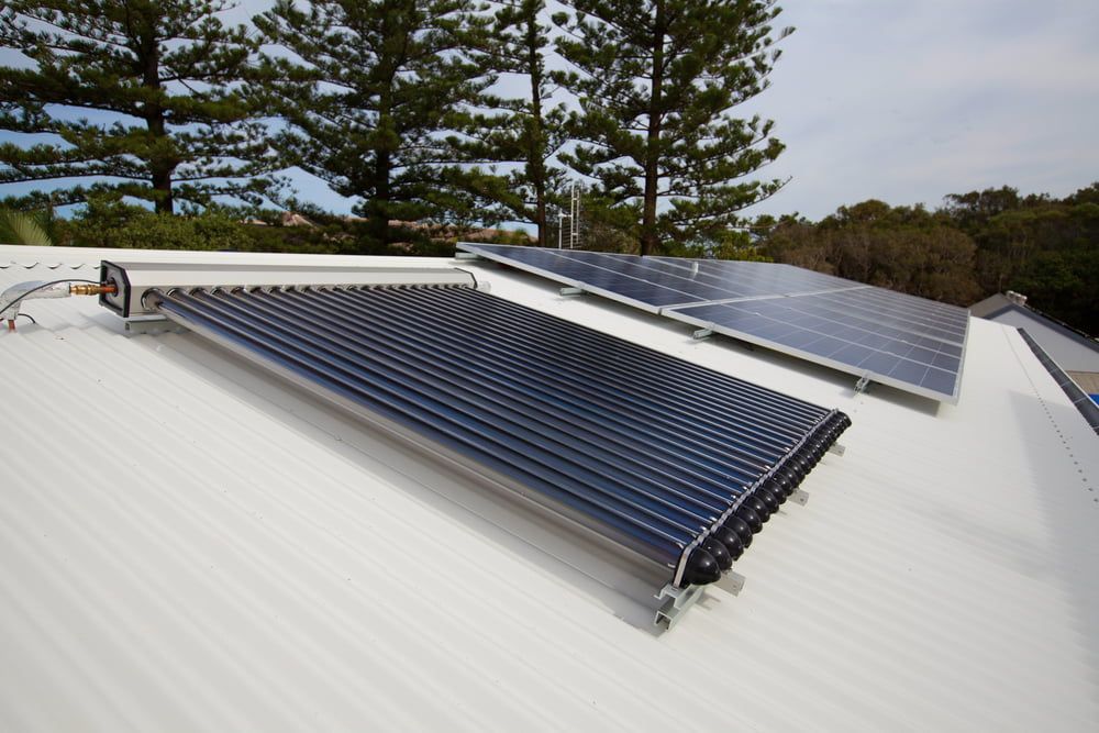 Two Solar Panels on a White Roof With Trees in the Background — Gunter Electrical In Gosford, NSW