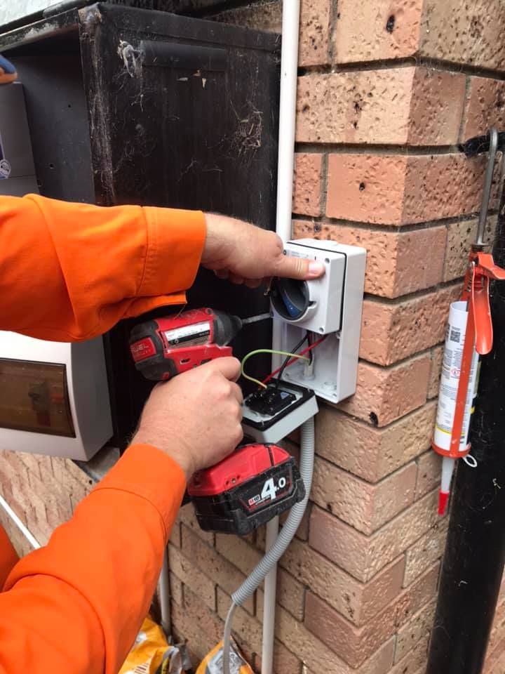 A Person is Fixing an Electric Meter With a Screwdriver — Gunter Electrical In Kariong, NSW