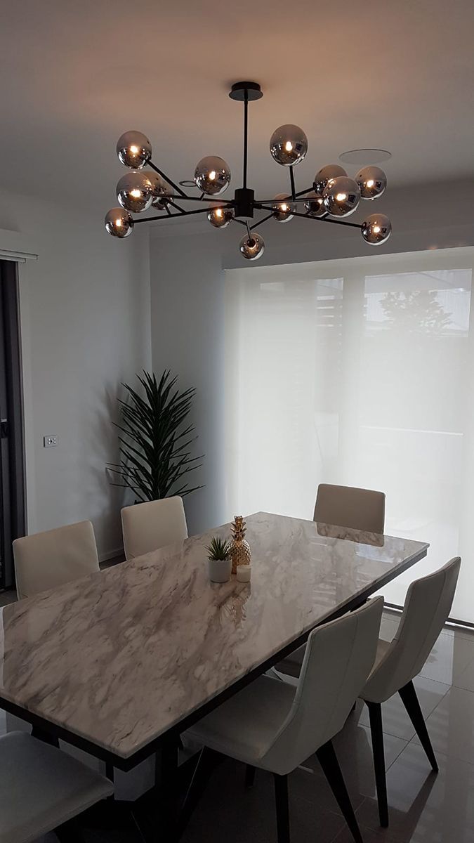 A Dining Room With a Table and Chairs and a Chandelier Hanging From the Ceiling — Gunter Electrical In Kariong, NSW