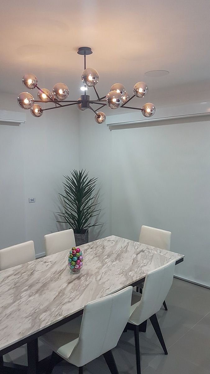 A Dining Room With a Table and Chairs and a Chandelier Hanging From the Ceiling — Gunter Electrical In Kariong, NSW
