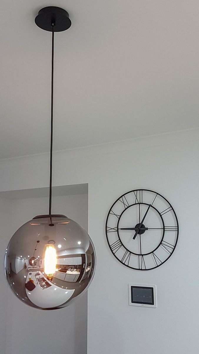 A Clock on a Wall Next to a Pendant Light — Gunter Electrical In Kariong, NSW