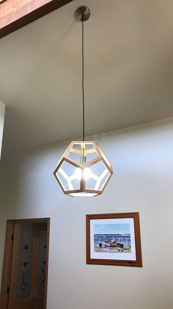 A Light Fixture is Hanging From the Ceiling in a Room With a Picture on the Wall — Gunter Electrical In Kariong, NSW