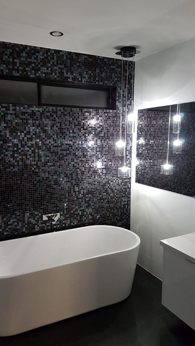 A Staircase With a Glass Railing and a Chandelier Hanging From the Ceiling — Gunter Electrical In Kariong, NSW